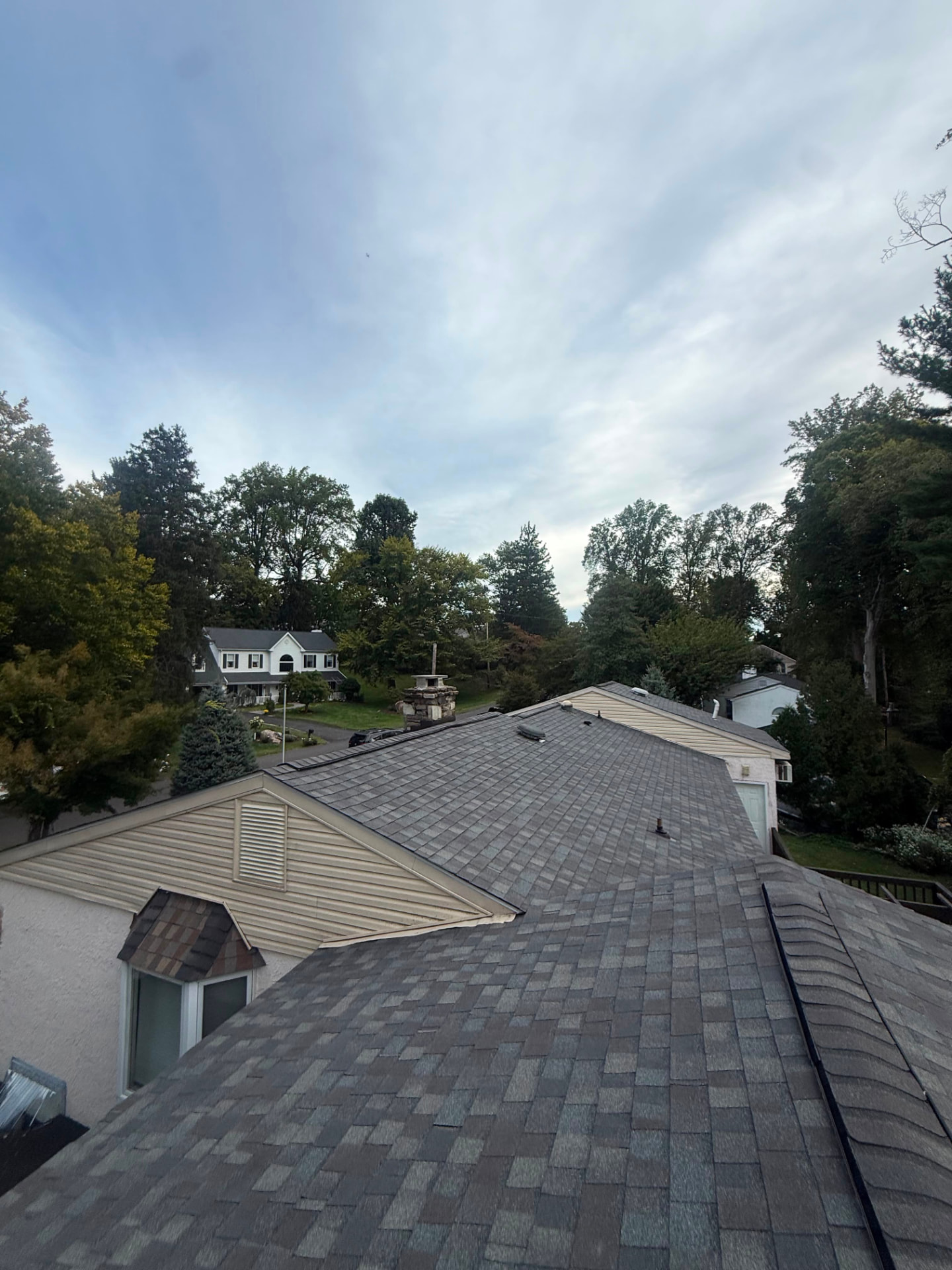 Completed multi-tone architectural shingle roof over a home with dormer and gables