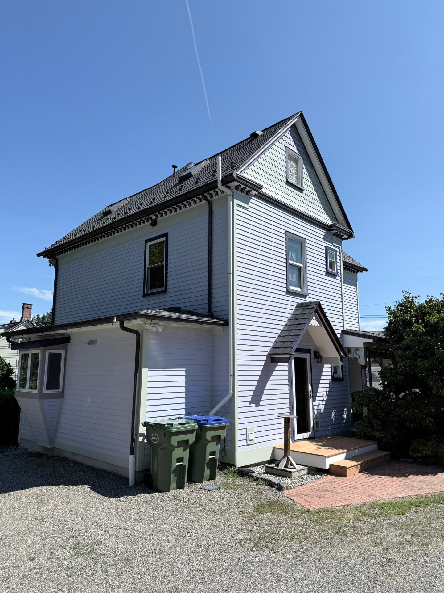 Rear corner of the painted house showing the side addition and back entry