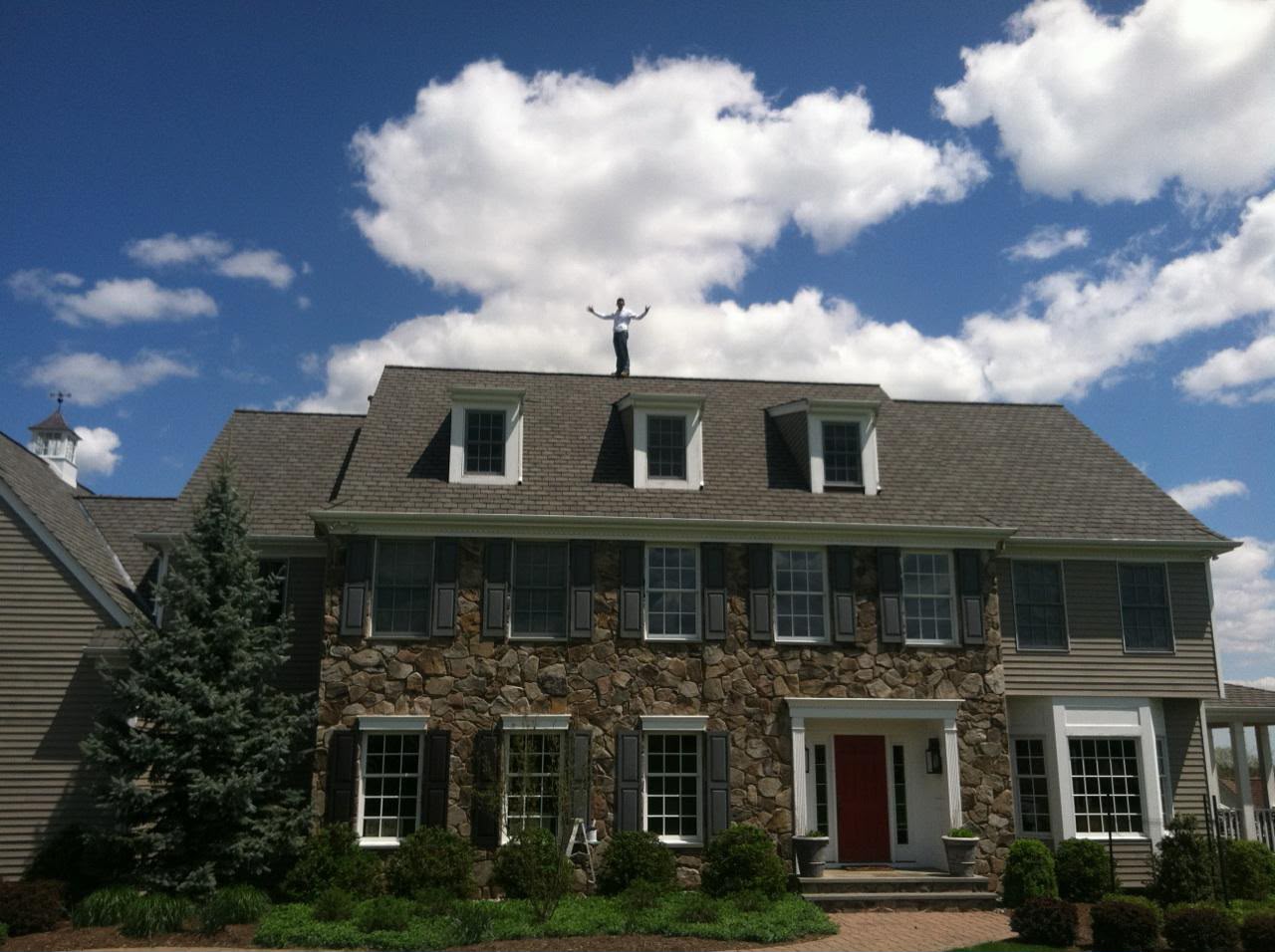 Stone Colonial home in Flemington, NJ with dormers, dark shutters and a red front door
