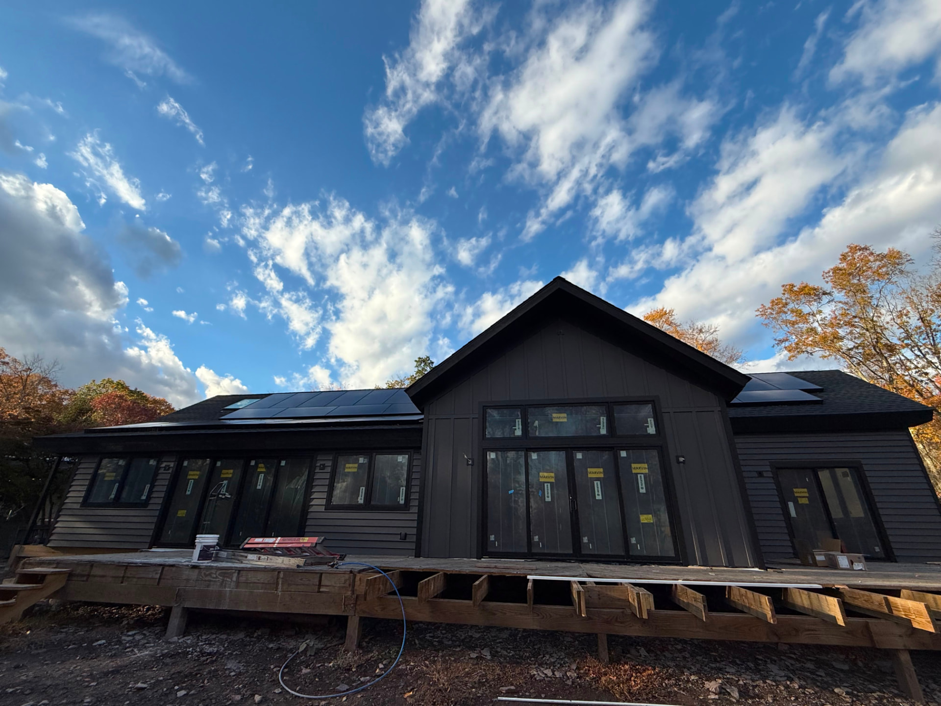 Pittstown, NJ home with deep charcoal siding, board-and-batten gable and large black-framed windows