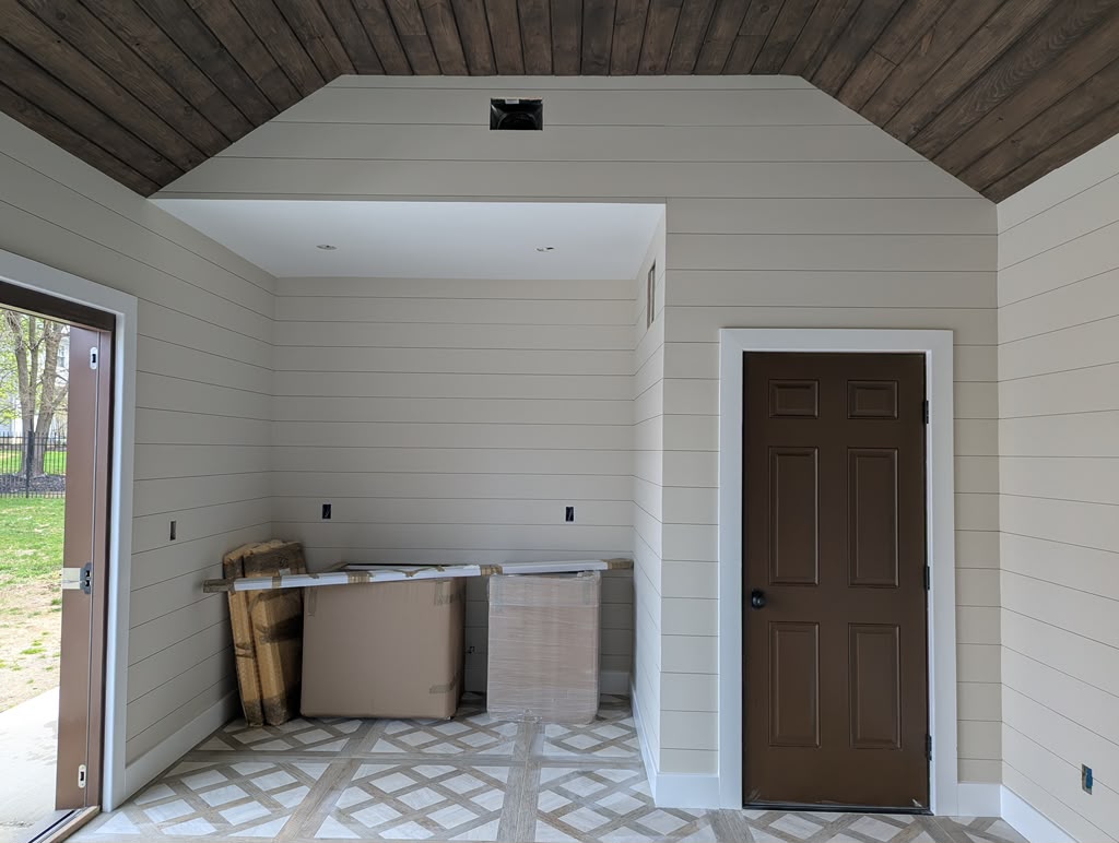 Finished pool house with shiplap, stained ceiling, white trim and tile floor