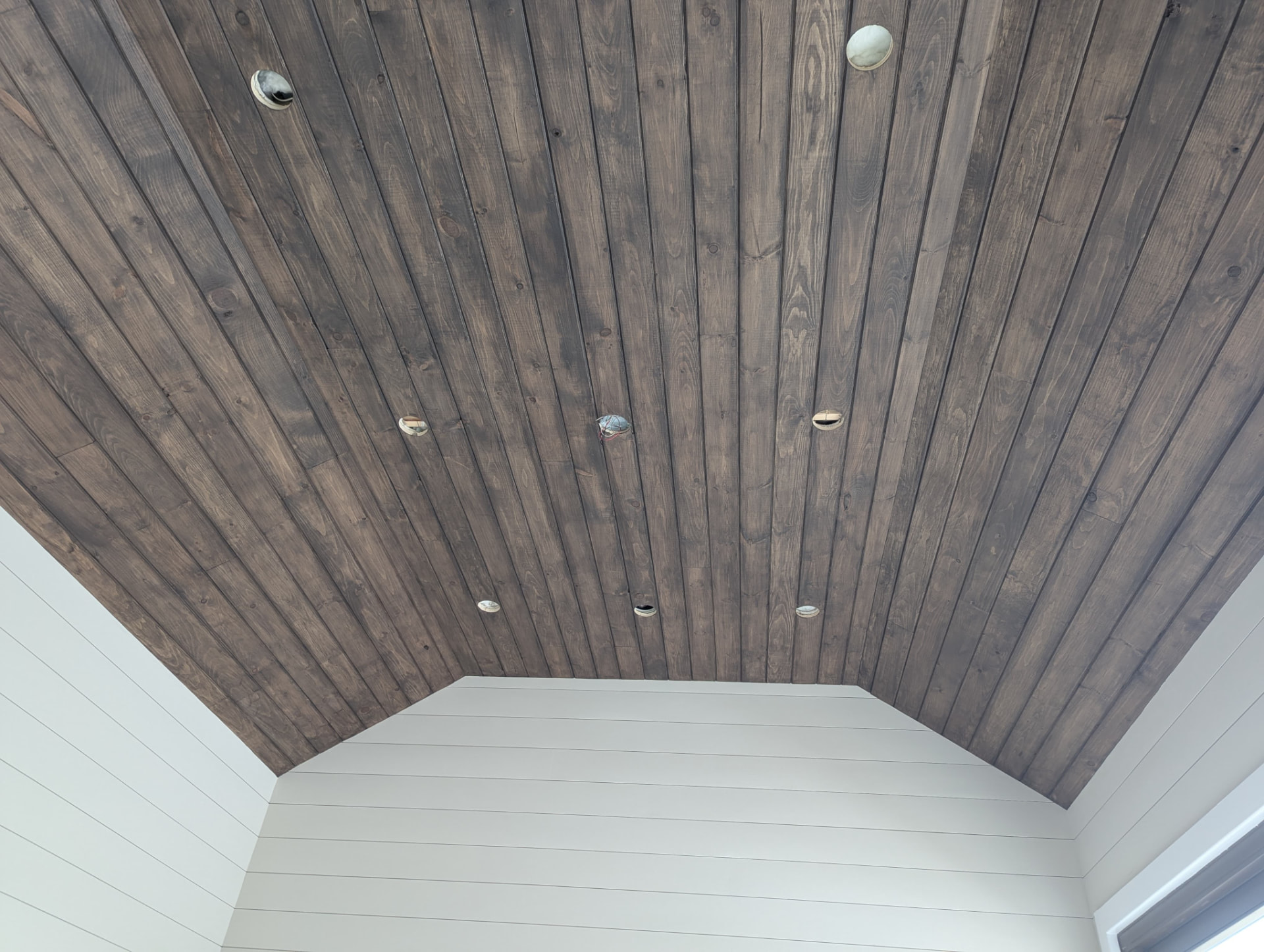 Stained tongue-and-groove vaulted ceiling with recessed light openings